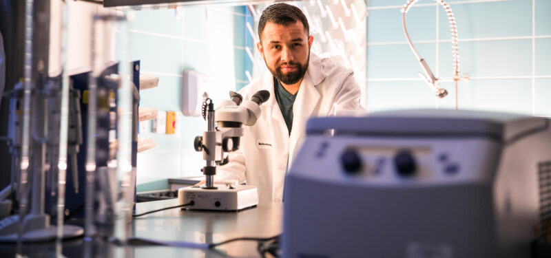 ACC student poses inside the ACC Bioscience Incubator.