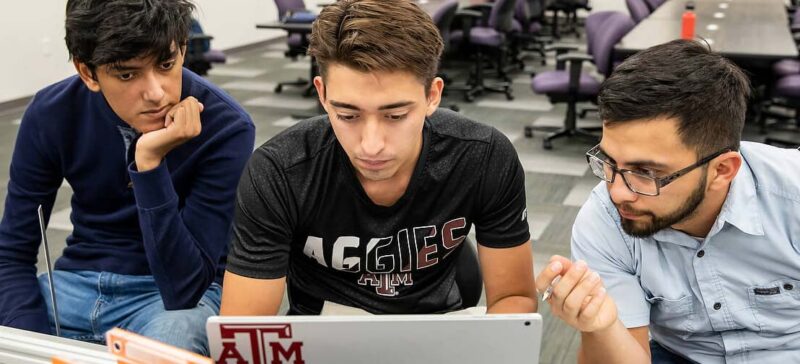 Students look at a laptop screen
